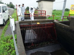 雨の中、水路のゴミ上げ作業